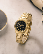 Gucci G-Timeless 32 mm Black Bee Dial Watch YA1265037 styled in a cafe lifestyle setting