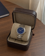 Gucci G-Timeless 32 mm Blue Lapis Bee Dial Watch YA1265043 presented in a luxury travel flat lay