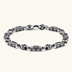 Oxidized silver stainless steel link bracelet with baguette blue CZ stones and intricate scroll engravings, lobster clasp.