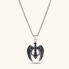 Silver stainless steel angel wing cross pendant necklace with green CZ center stone and black crystals on a box chain.