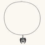 Silver stainless steel angel wing cross pendant necklace with green CZ center stone and black crystals on a box chain.