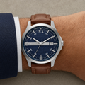 Armani Exchange AX2155 men's silver watch with navy dial and brown leather strap on wrist