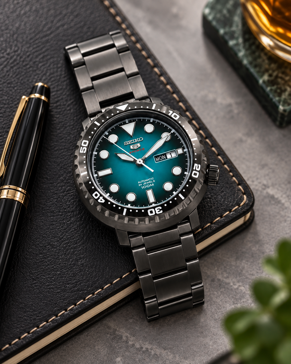 Seiko 5 Sports SRPC65J1 automatic turquoise green dial black stainless steel watch desk view
