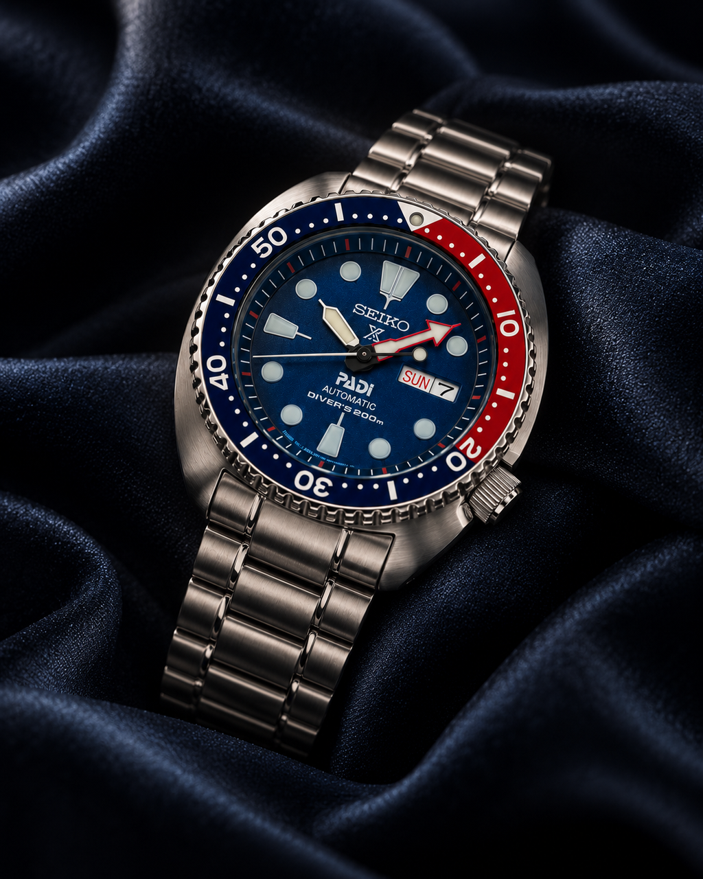 Seiko Prospex PADI Turtle SRPE99 automatic diver's watch on dark navy satin, blue dial and stainless steel bracelet
