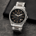Armani Exchange AX1093 silver chronograph watch on a dark desk