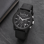 Armani Exchange AX1326 black chronograph watch on a dark desk