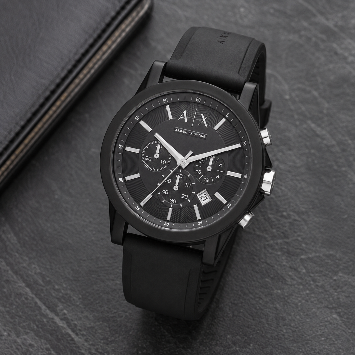 Armani Exchange AX1326 black chronograph watch on a dark desk